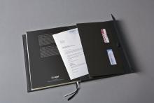 Büromappe mit Dokumenten und Visitenkarten auf grauer Oberfläche