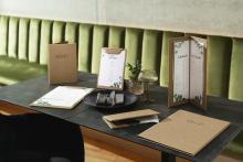 Menüs und Weinkarten auf Tisch mit grüner Polsterbank