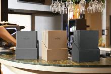 Drei Menühalter mit Menüs auf Theke Im Hintergrund hängen Gläser