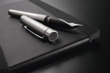 Füllfederhalter auf schwarzem Notizbuch