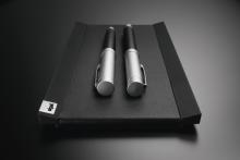 Zwei silberne Stifte auf schwarzer, lederartiger Unterlage