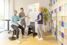 Three people discussing products on a whiteboard