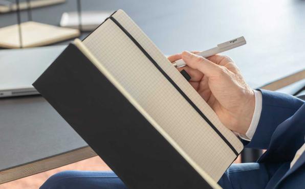 Mann schreibt in offenes Notizbuch