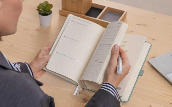 Frau blättert in Conceptum Kalender