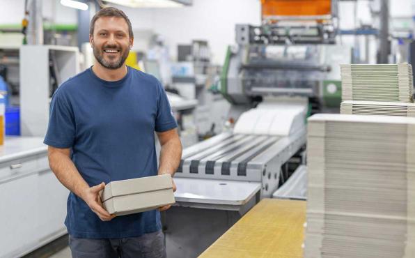 Drucker bei SIGEL Printworks mit verpacktem Endprodukt