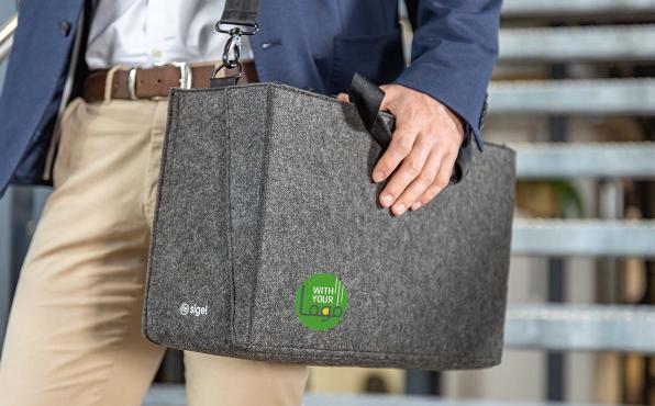 Ein Mann trägt eine dunkelgraue Filz-Businesstasche mit Logoaufdruck über der Schulter