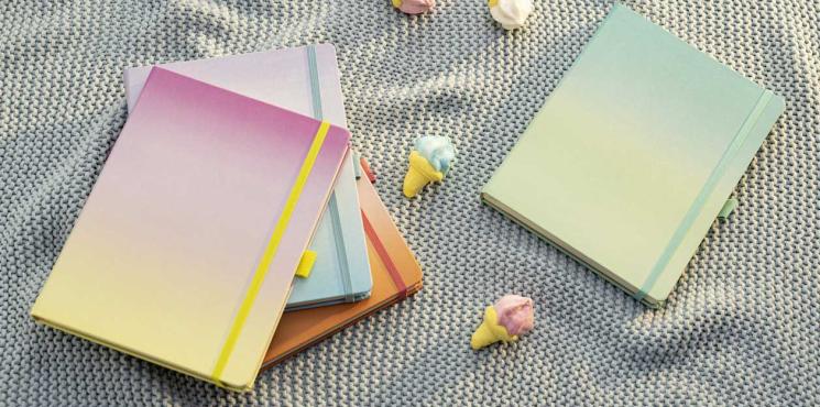 Jolie Bullet Journals in Watercolor-Optik liegen auf grauem Tuch