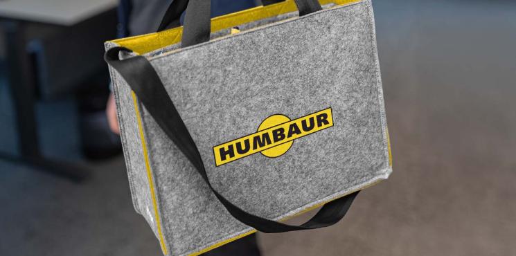 Die graue Businesstasche aus Filz zeigt ein Logo der Firma Humbaur