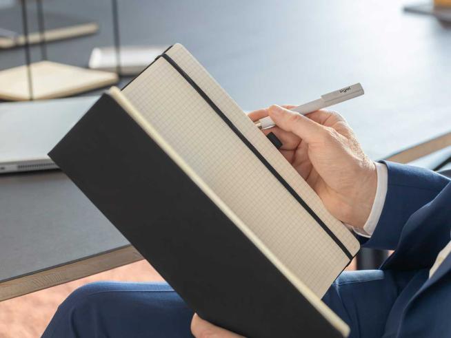 Mann schreibt in offenes Notizbuch