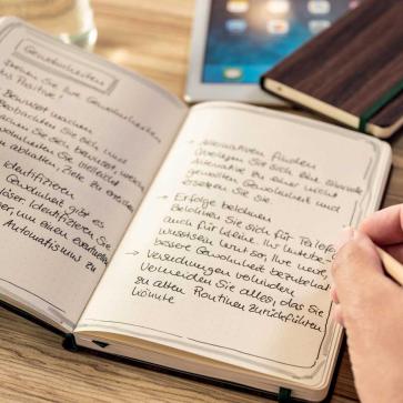 Hand schreibt in Notizbuch