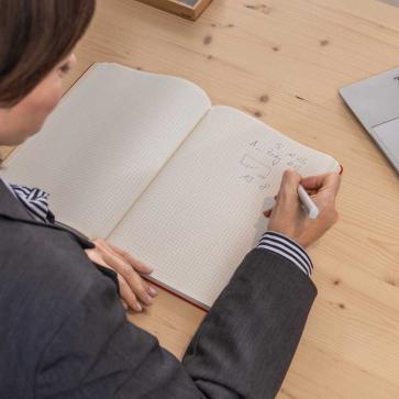Frau notiert in Notizbuch