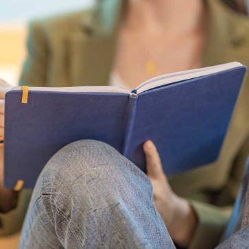 Frau schreibt in Notizbuch